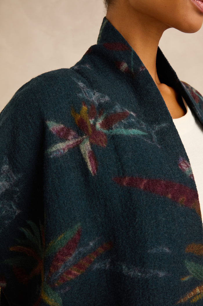 Close-up of a woman wearing the Abstract Floral Wool Gilet over a white top, with only her neck, shoulder, and part of her face visible. The brushed wool fabric of the gilet adds soft texture to the elegant layering.