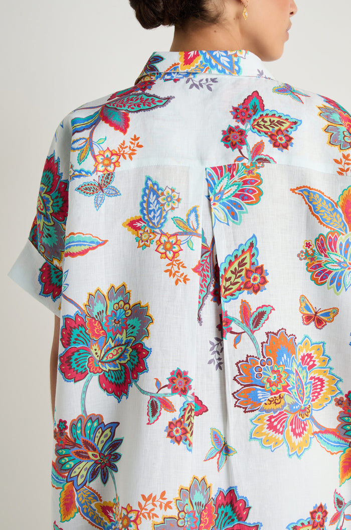 Person wearing the Botanical Linen Long Shirt with a vibrant multicolored botanical print, shown from the back and side.