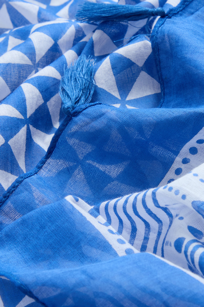 Close-up of the Cobalt Tassel Cotton Scarf, showcasing its blue and white geometric print and delicate tassel edging along the seam.