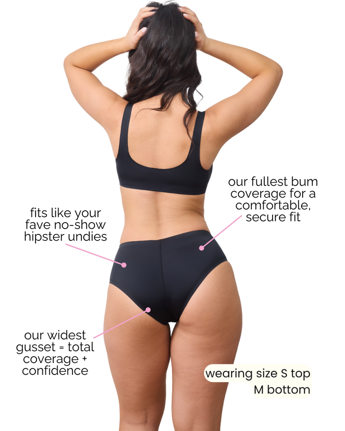 Back view of Compo Hipster Bikini Bottom in black on model showing fullest bum and hip coverage with raw-cut no-show edges