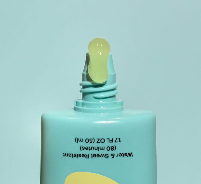 Turquoise sunscreen bottle on light blue background