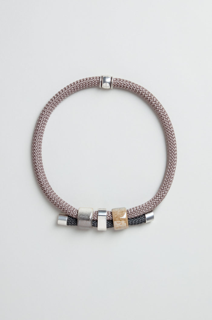 The braided bracelet with silver and gold-tone beads pairs beautifully with the Layered Marble Bead Cord Necklace for an elegant, coordinated look.