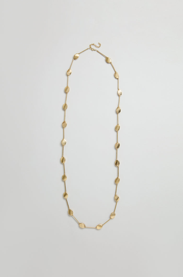 The Long Oval Disc Necklace features textured oval discs evenly spaced along its metallic chain, showcased on a plain light background.