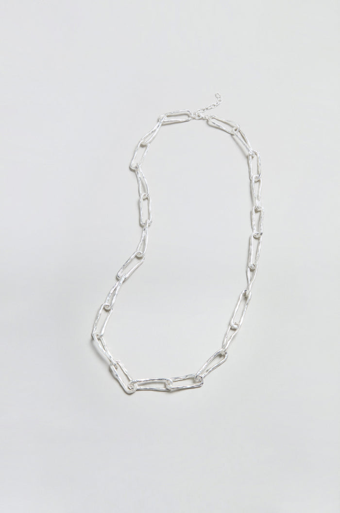 The Long Silver Links Necklace is displayed on a plain, light background. Featuring elongated, rectangular links and a refined, textured chain design, this necklace adds a touch of elegance to any ensemble.