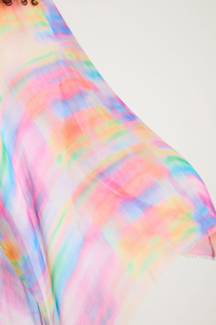 A close-up of the Painted Horizon Kimono, featuring a flowing, semi-sheer fabric with a watercolor-inspired multicolored pattern in pink, blue, green, yellow, and orange hues.