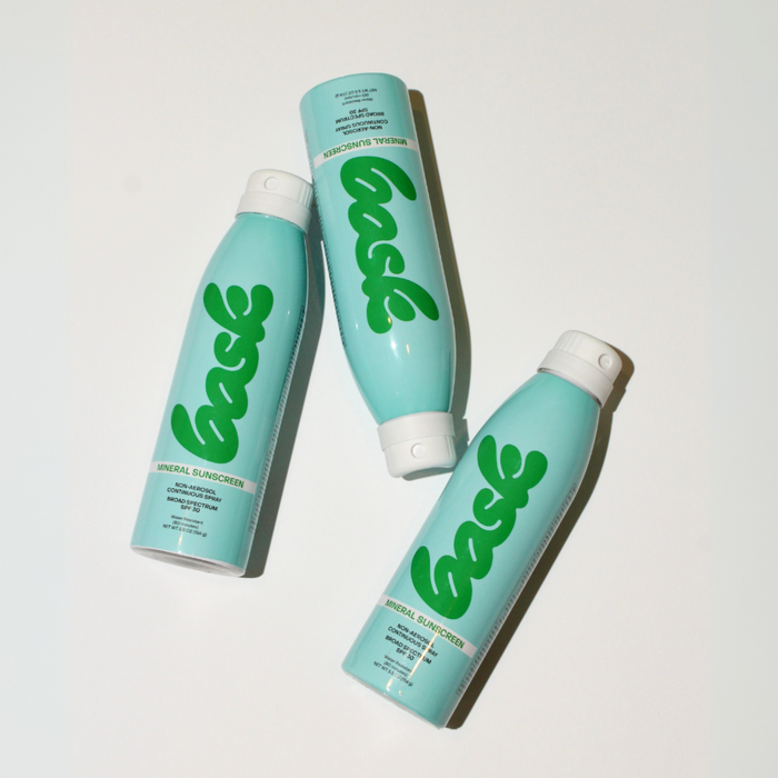 Top-down view of three Bask SPF 30 mineral non-aerosol spray cans on a white background