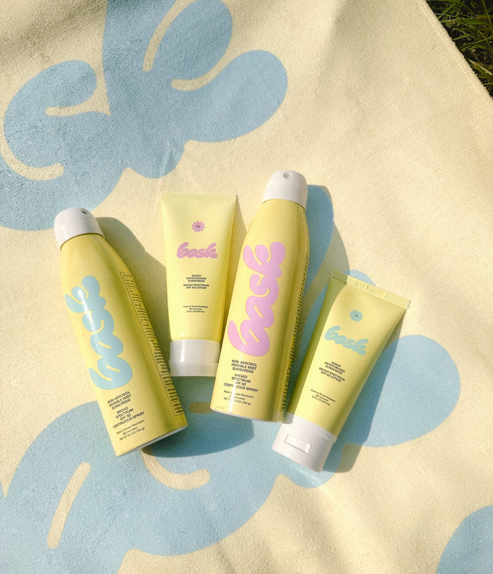 Overhead view of The Core Four bundle showcasing four SPF 30 and 50 lotions and sprays on a sunlit yellow and blue background
