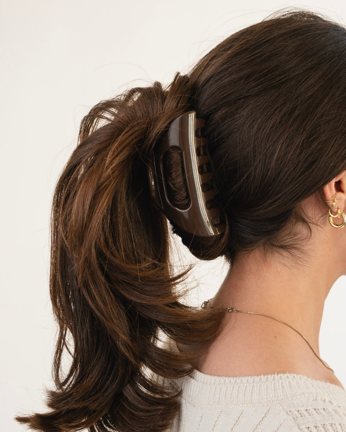 Brown claw Cozy Clip hair clip holding a ponytail at the back of a woman's head