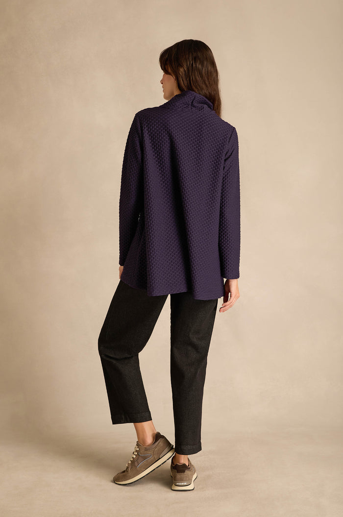 A person stands with their back to the camera, wearing the Waffle Textured Jersey Damson Cowl Neck Top, black pants, and taupe sneakers against a neutral background.